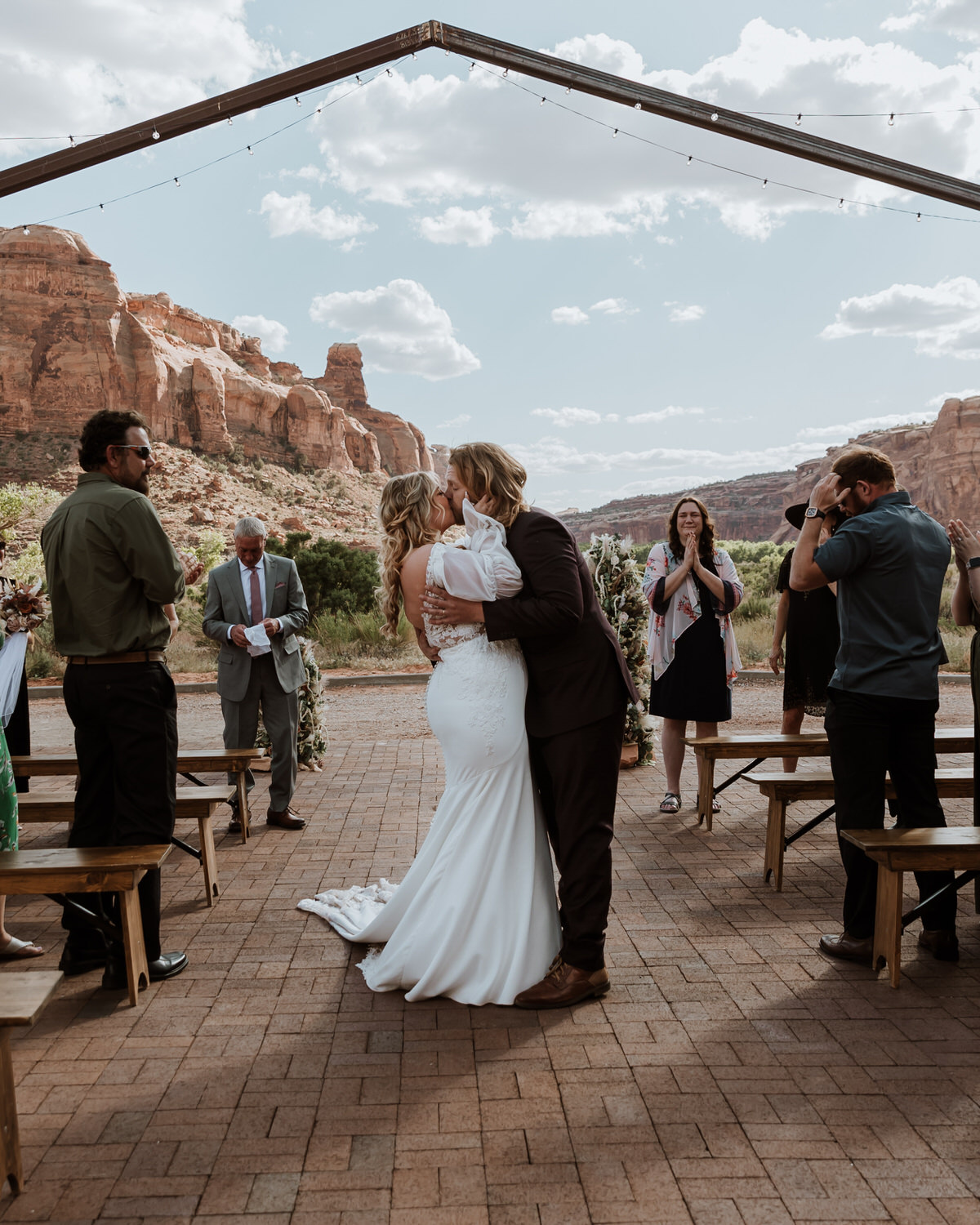 Bride and Groom having their first kiss at the red earth venue in moab utah