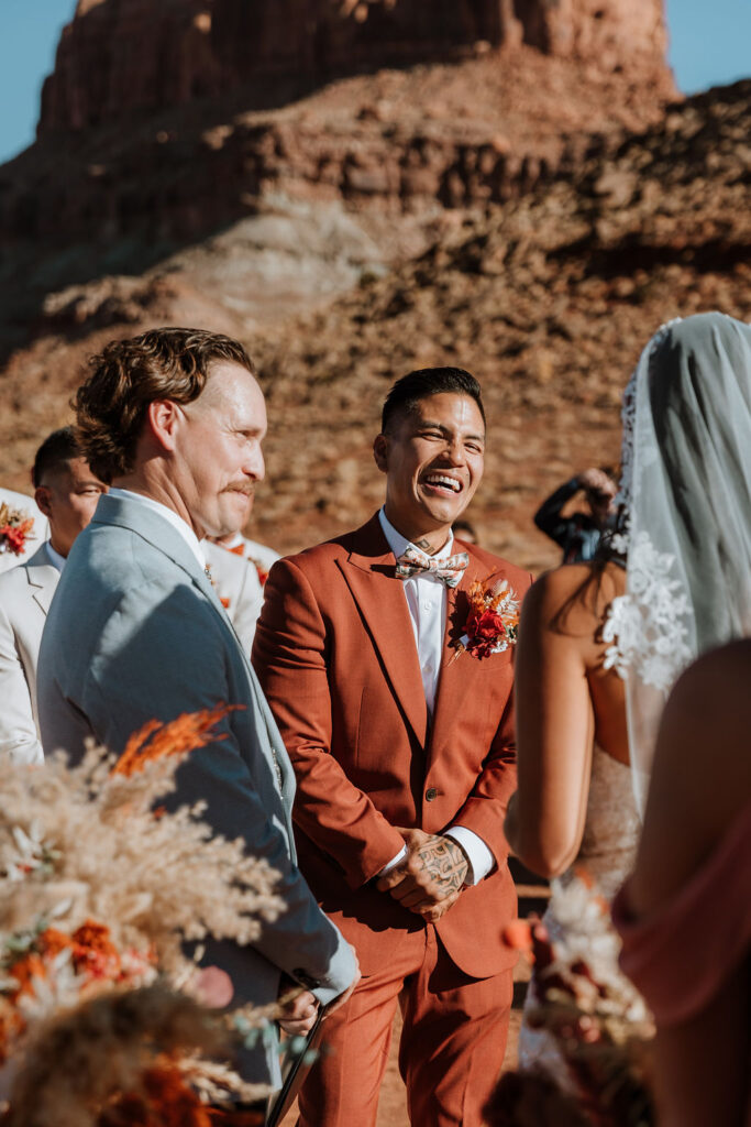 groom laughing at a wedding in the desert