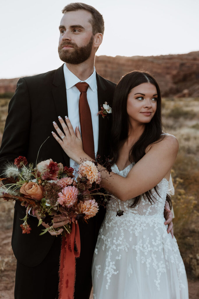 couple embraces in field at Moab elopement
