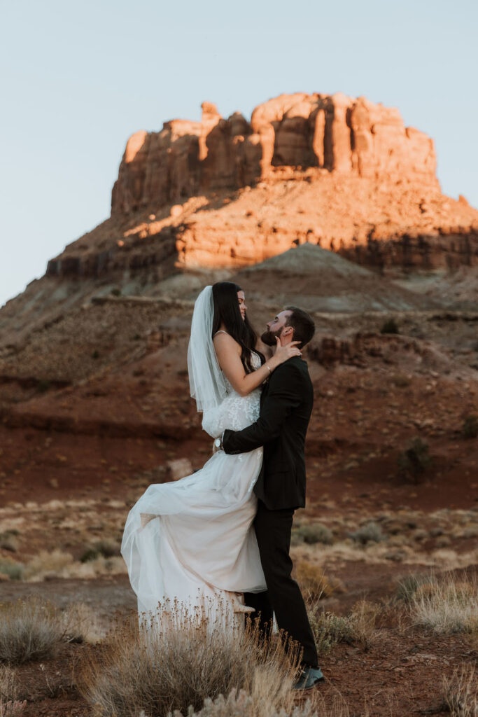 couple embraces in field at Moab elopement