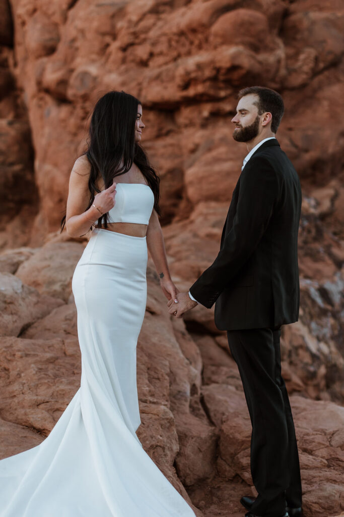 couple holds hands at Arches National Park sunrise elopement