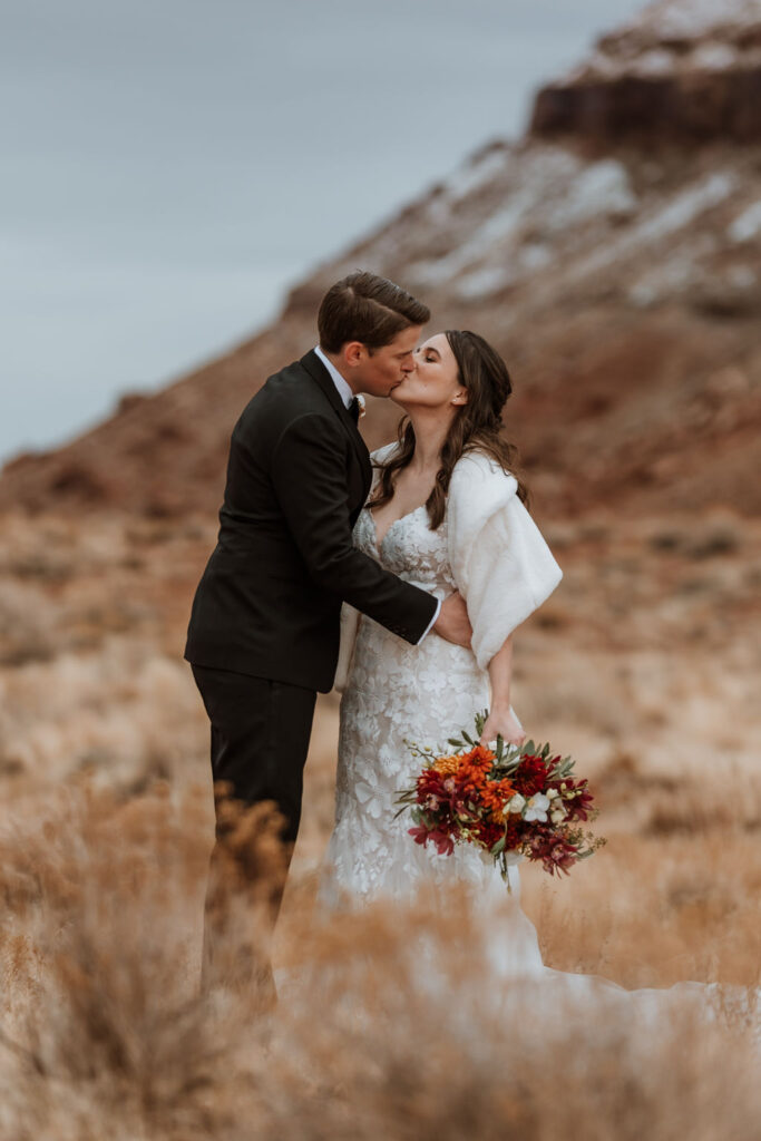 couple kisses at outdoor winter wedding in Moab