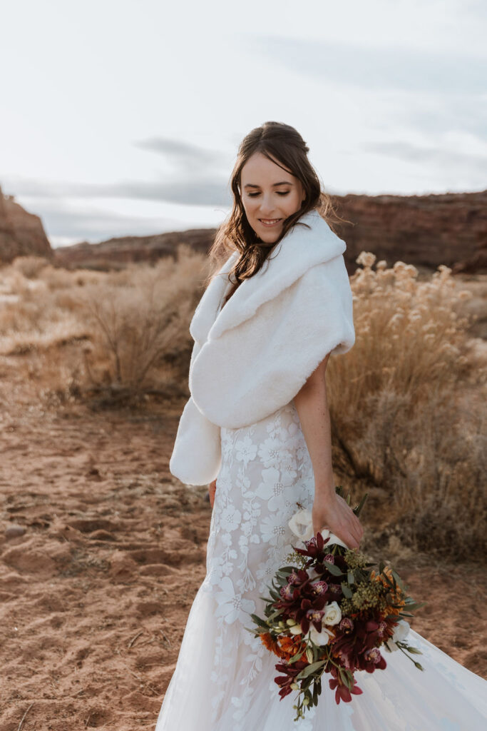 bride wears long winter wedding dress with fur winter wedding shawl