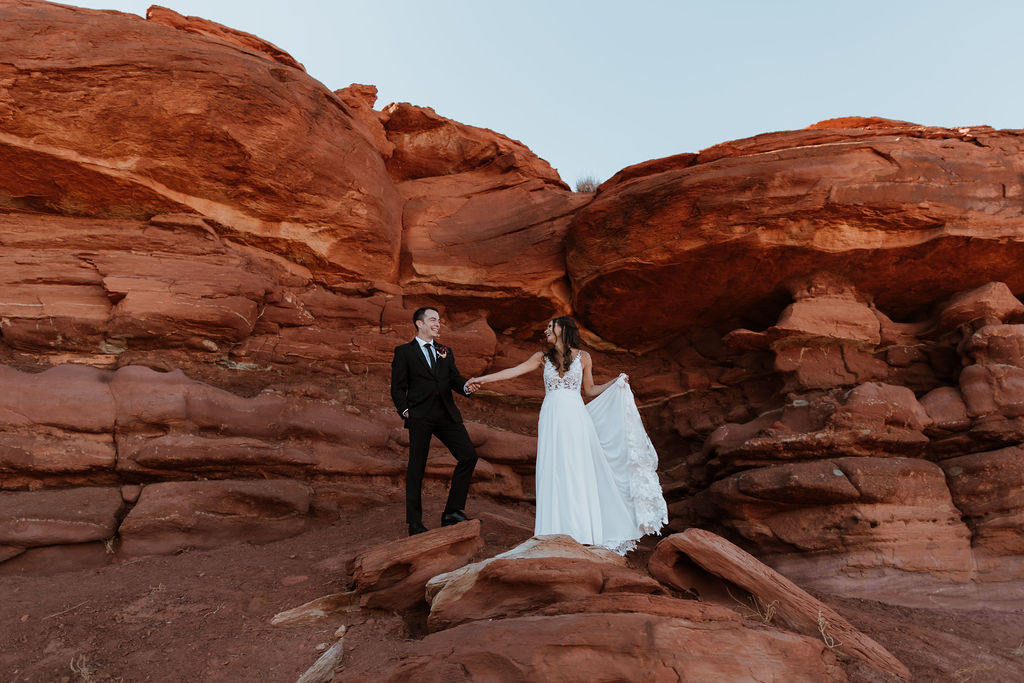 couple walks along moab utah desert red rock
