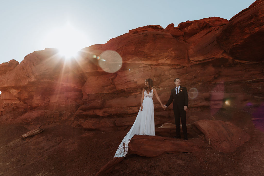 couple holds hands under moab utah desert red rock