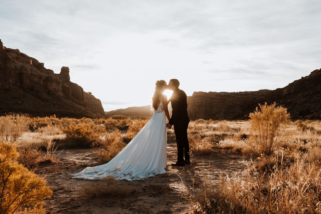couple kisses at Moab sunset desert elopement