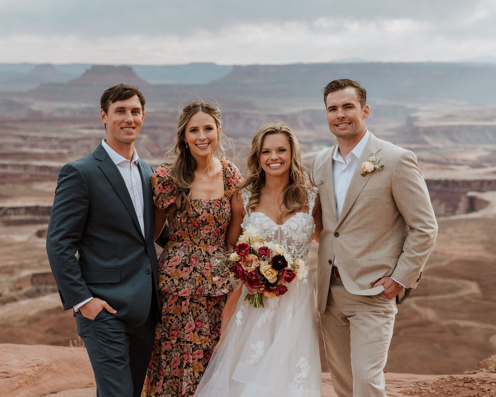 couple poses with wedding guests and officiant 