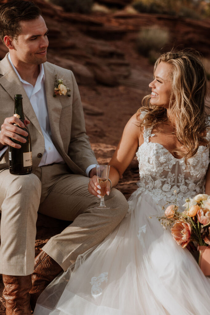couple drinks champagne at sunset elopement