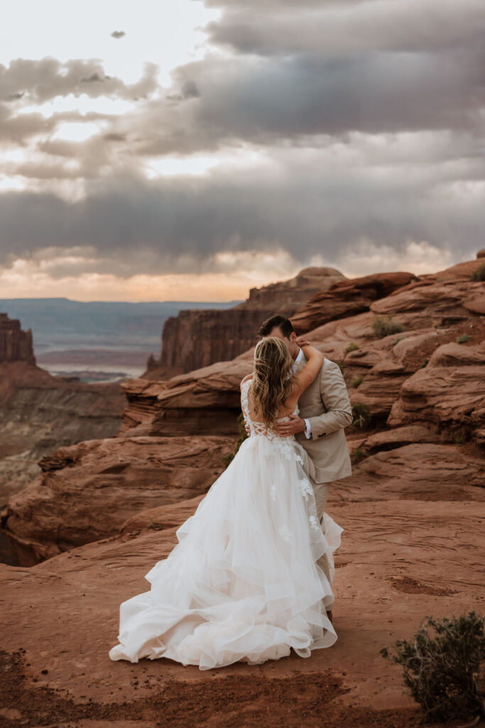 couple kisses at Moab sunset elopement