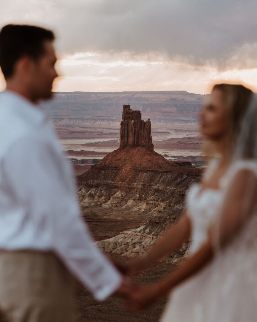 red rock formations in background at Moab sunset elopement