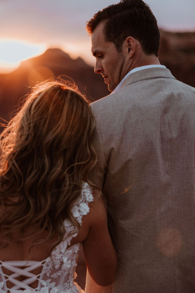 couple sits together at outdoor Moab sunset elopement