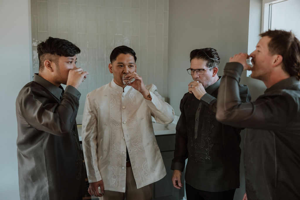 groom drinks with groomsmen on wedding day