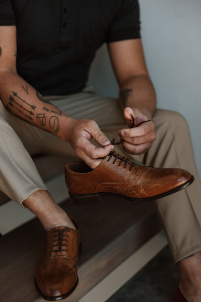 groom puts on wedding shoes