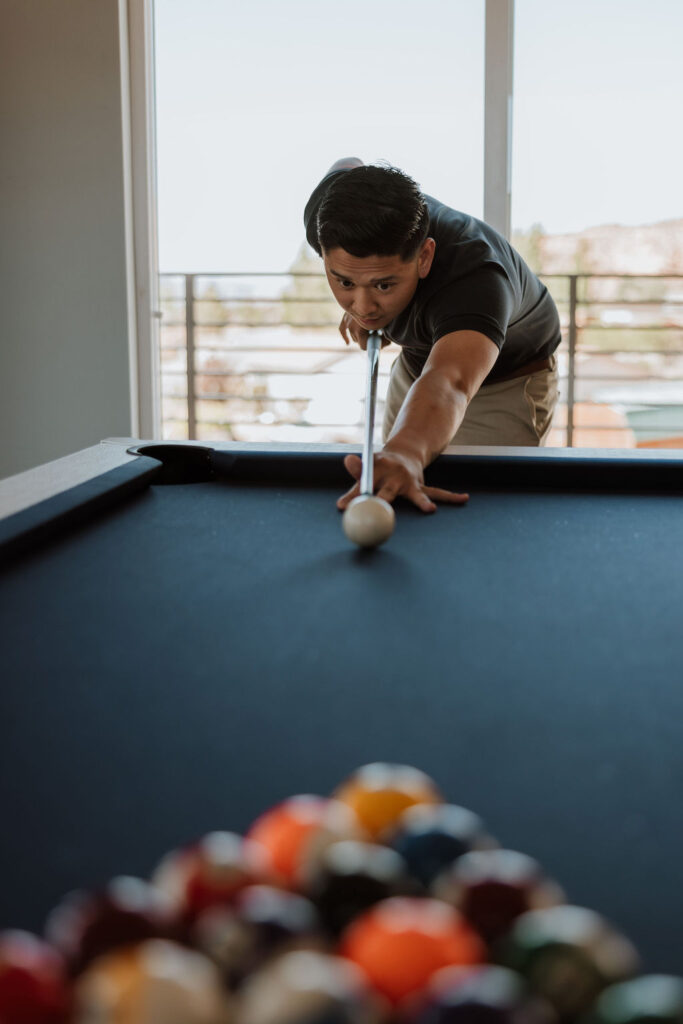 groom playing pool on wedding day