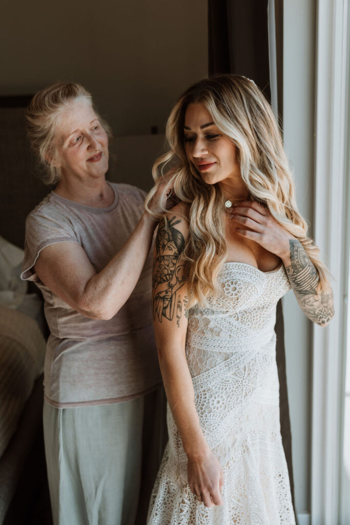 mother of bride puts jewelry on bride