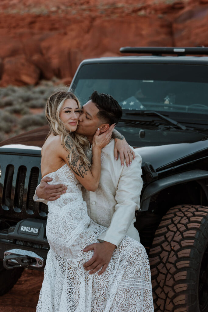 couple poses with Jeeps at Moab sunset desert elopement