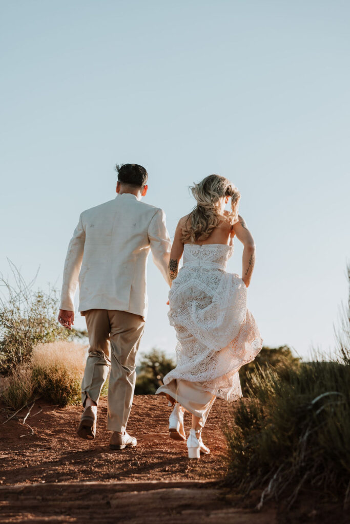 couple walks holding hands at Moab couples adventure