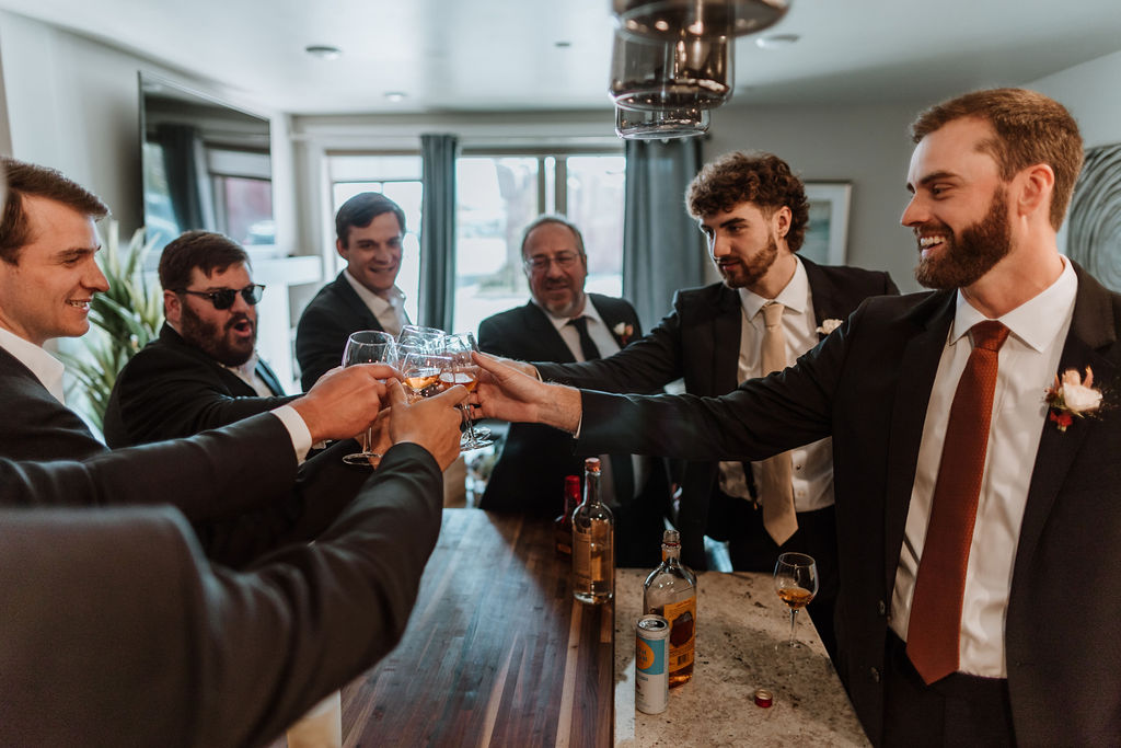 groom cheers with groomsmen