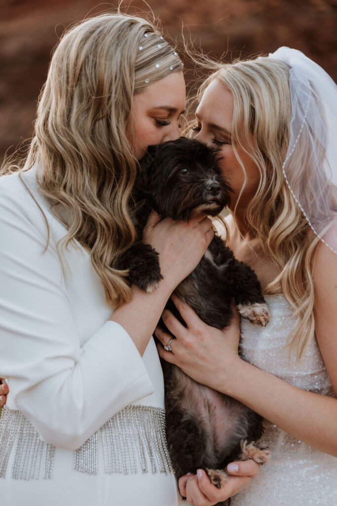 couple kisses dog at outdoor Moab elopement 