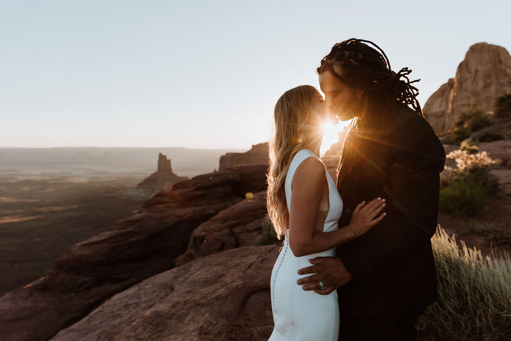 couple kisses at Moab sunset desert elopement