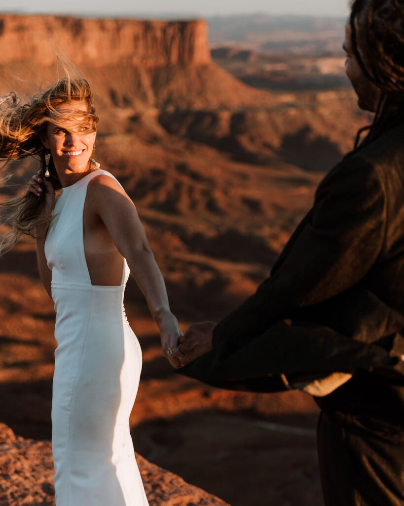 couple holds hands at Moab sunset desert elopement