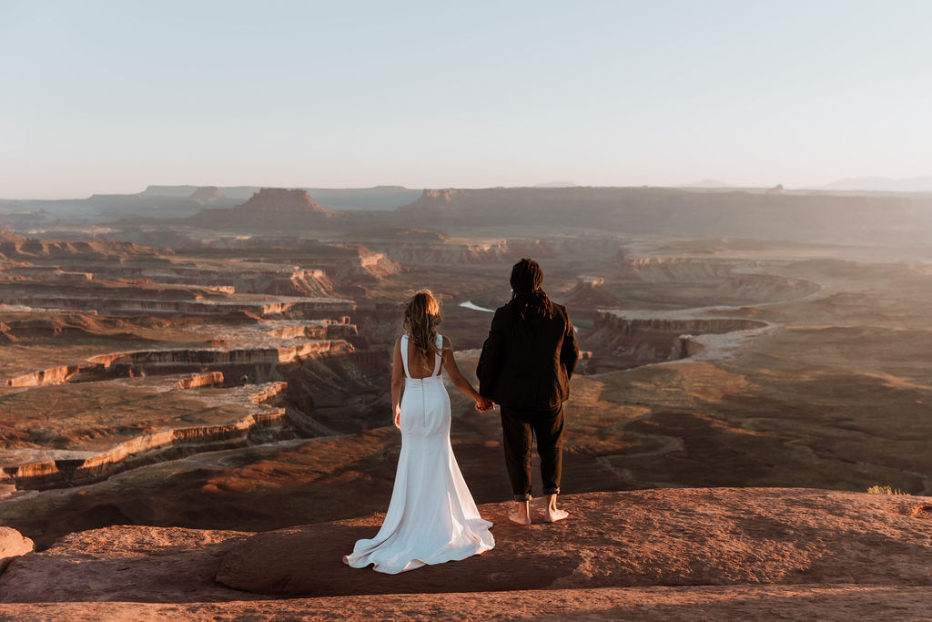 couple holds hands at Moab sunset desert elopement