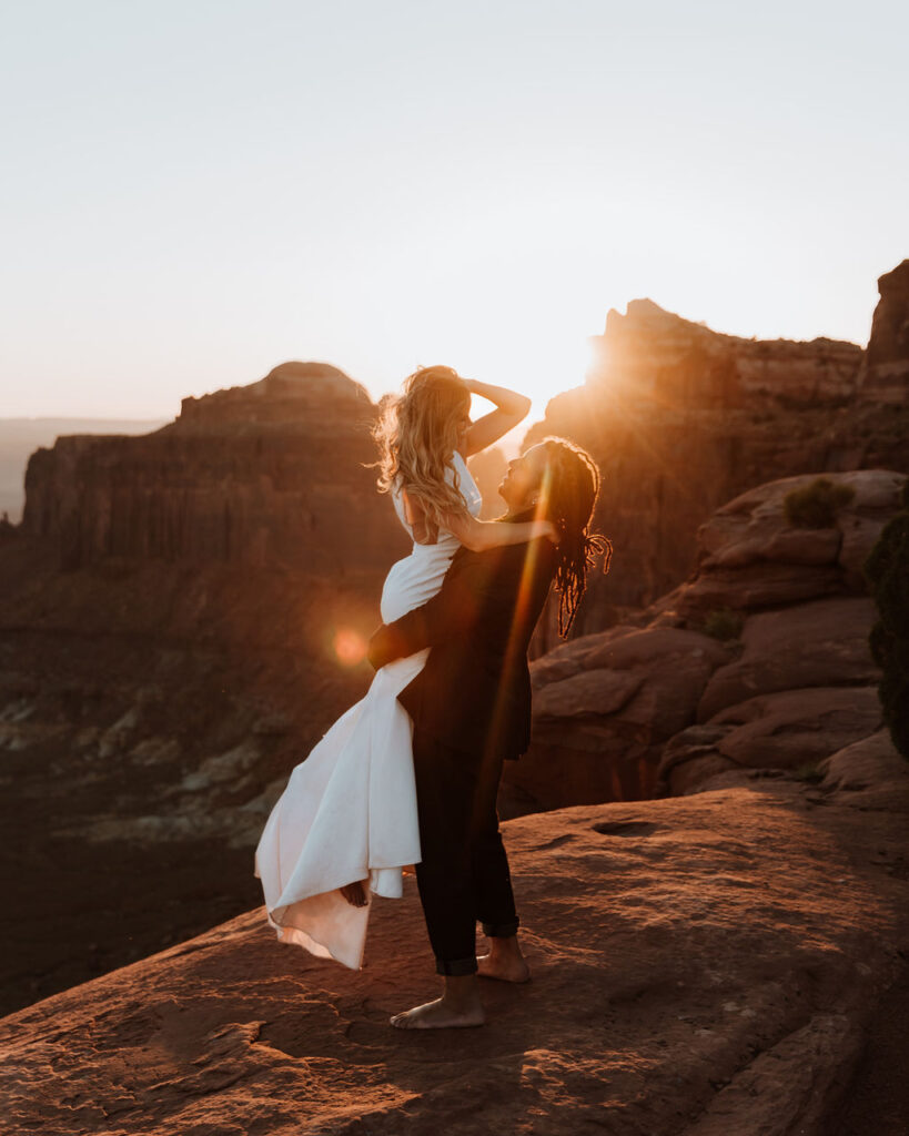 couple embraces at Moab sunset desert elopement