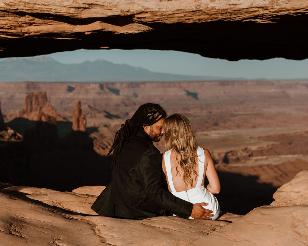 couple sits at Moab sunset overlook