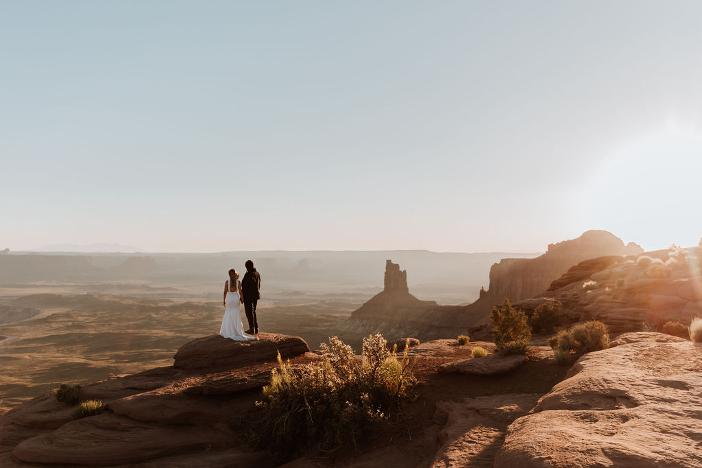 couple stands at overlook for Moab desert elopement 