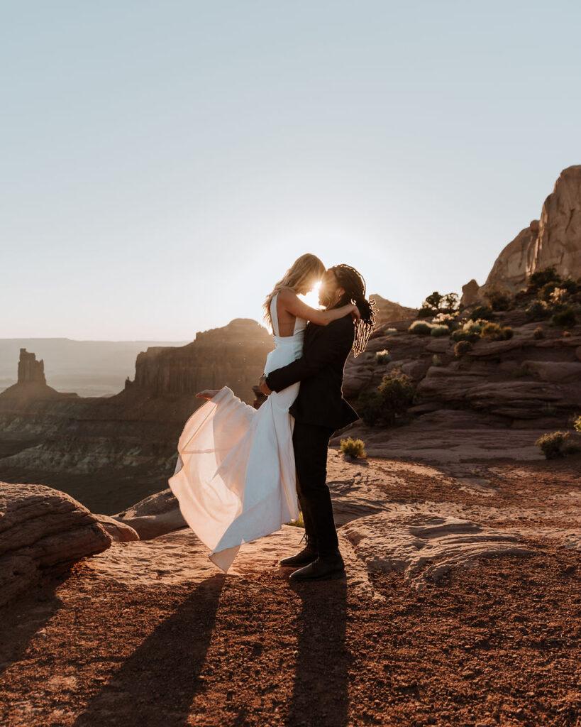 couple embraces at Moab sunset desert elopement