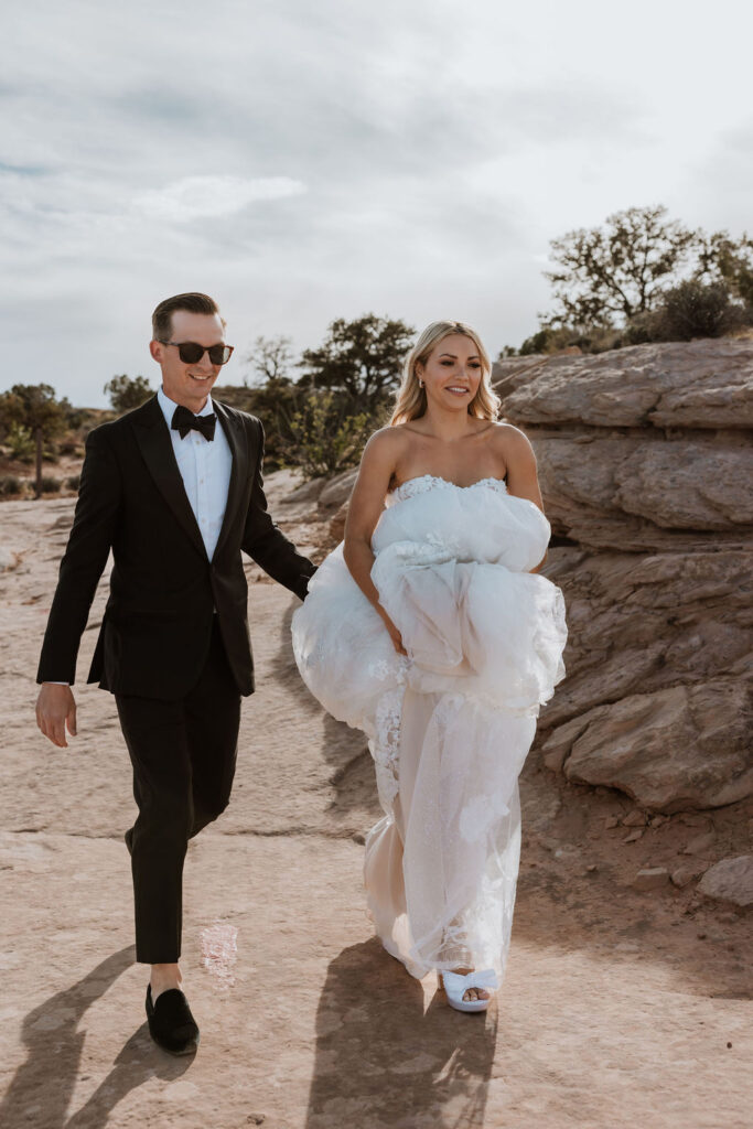 couple hikes at Moab sunset elopement 