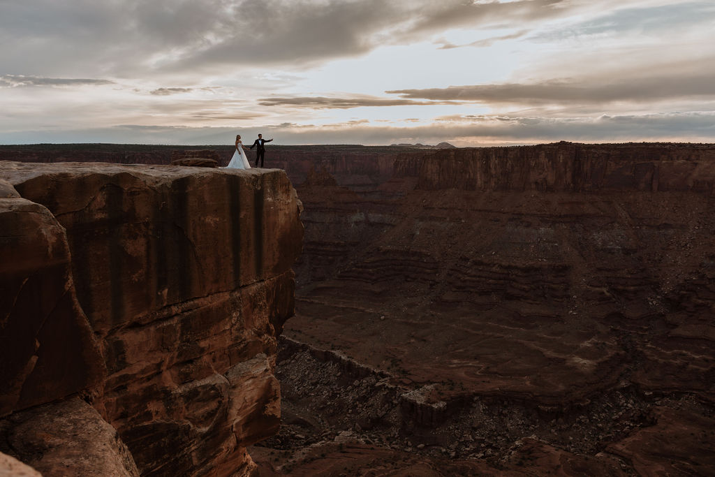 couple holds hands at Dead Horse Point Overlook
