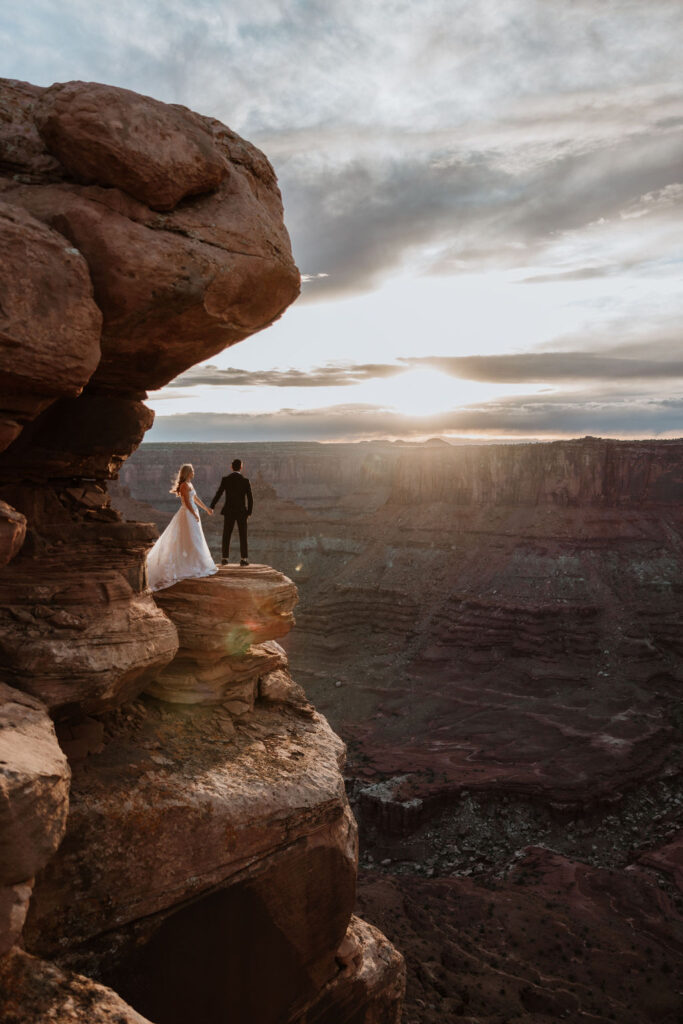 couple holds hands at Dead Horse Point Overlook
