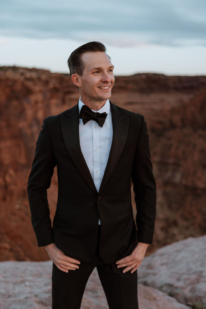 groom poses at Moab sunset elopement