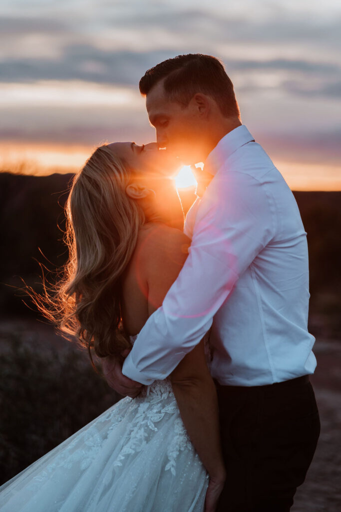 couple kisses at Moab sunset elopement