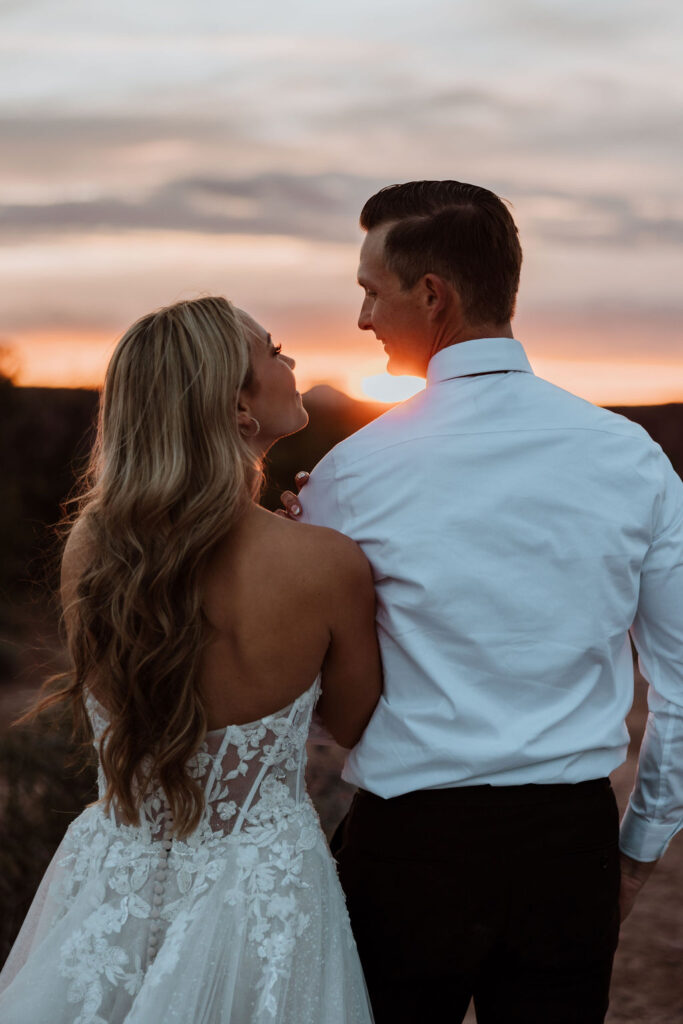 couple embraces at Moab sunset elopement