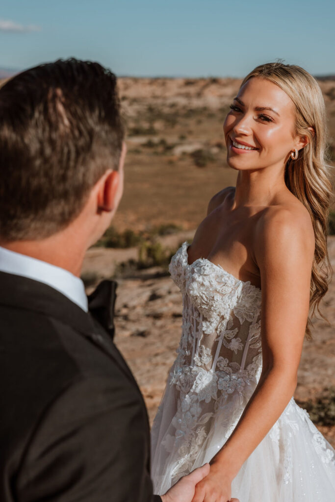 couple holds hands at Moab sunset elopement 