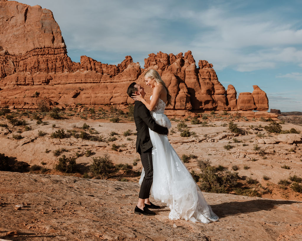 couple embraces at Moab sunset elopement 