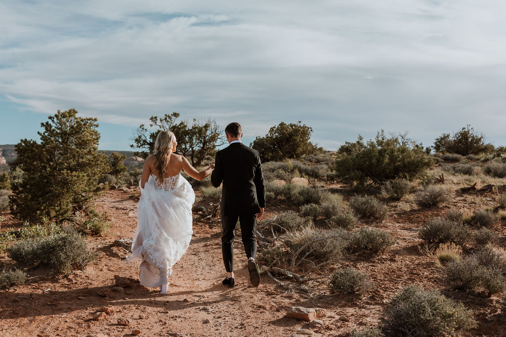 couple hikes at Moab sunset elopement 