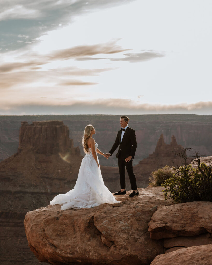 couple holds hands at Dead Horse Point Overlook