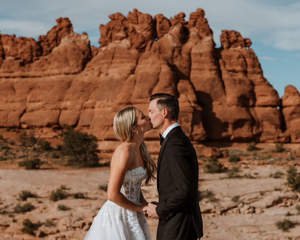 couple kisses at Moab sunset elopement 