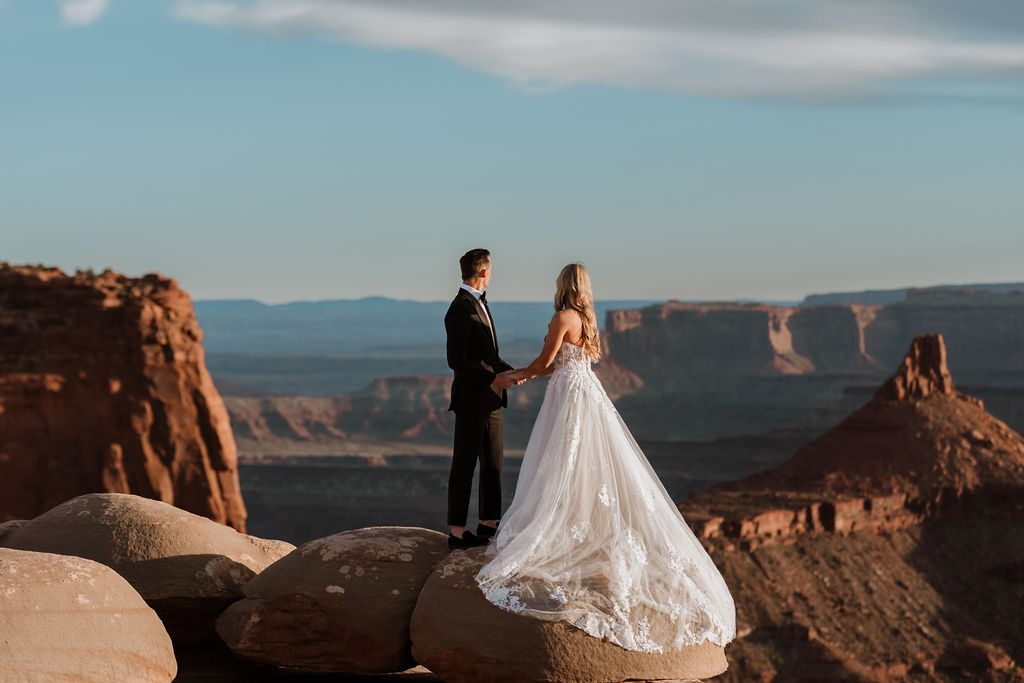 couple holds hands at Dead Horse Point Overlook