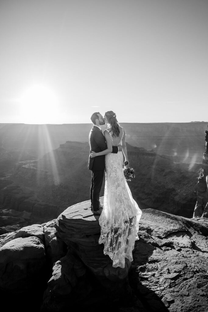 couple kisses on overlook at Dead Horse Point State Park Moab elopement 