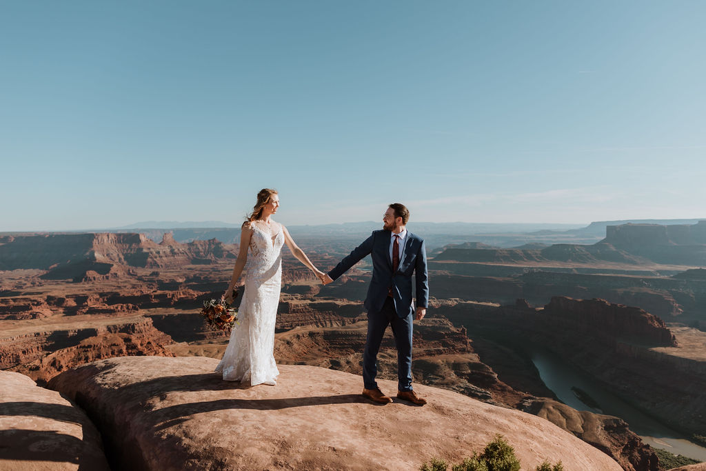 couple walks holding hands at Dead Horse Point State Park Moab elopement 