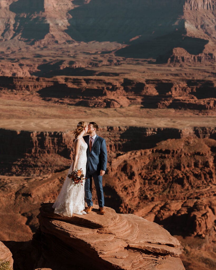 couple kisses on overlook at Dead Horse Point State Park Moab elopement 