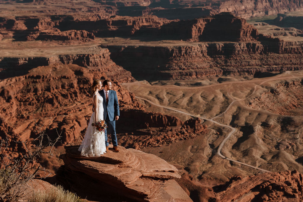 couple embraces on top of Moab overlook