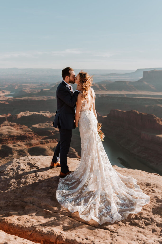 couple kisses on top of Moab overlook