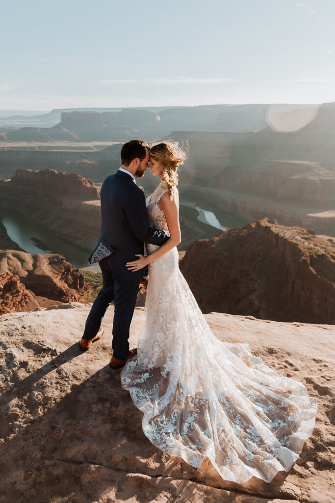 couple stands at overlook at outdoor Moab desert elopement