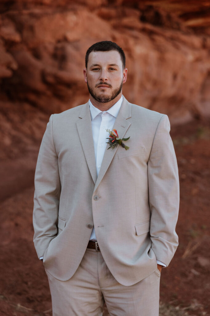 groom poses at red rock elopement