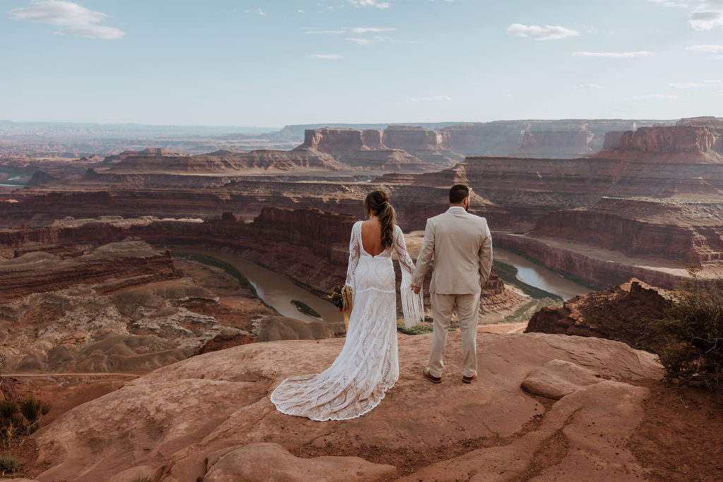 couple stands on overlook at Dead Horse Point State Park Moab elopement